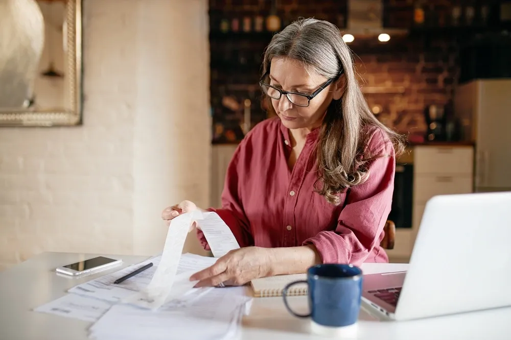Mulher analisando extrato bancário e boletos