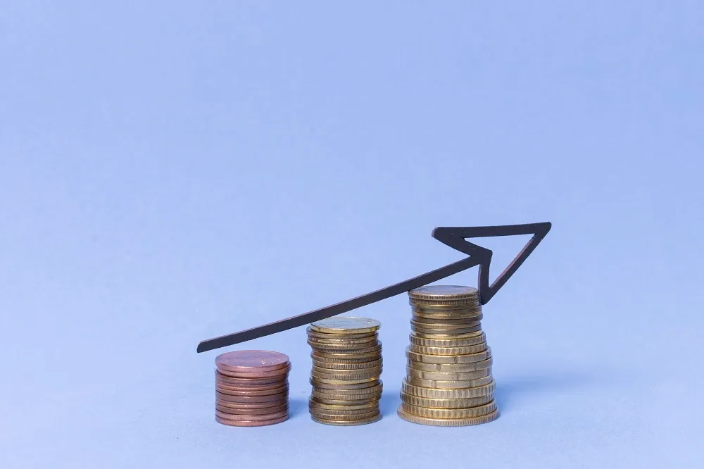 Moedas empilhadas com seta apontando para cima