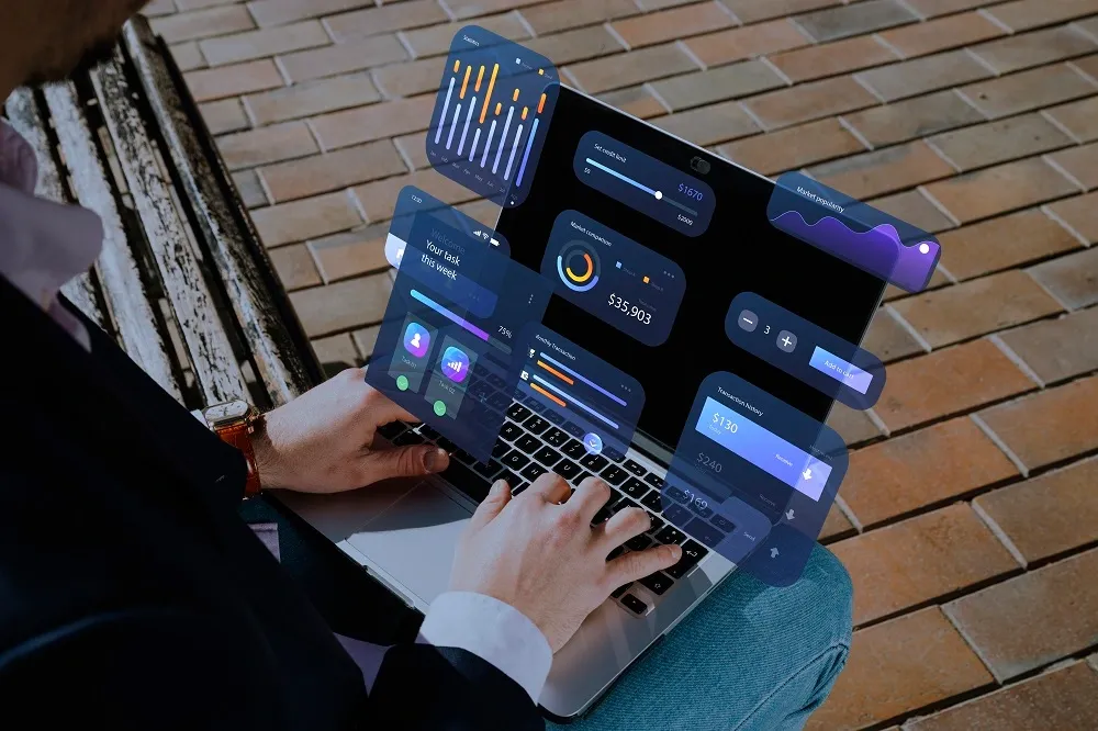 Homem usando notebook com ícones de dashboard saltando da tela.