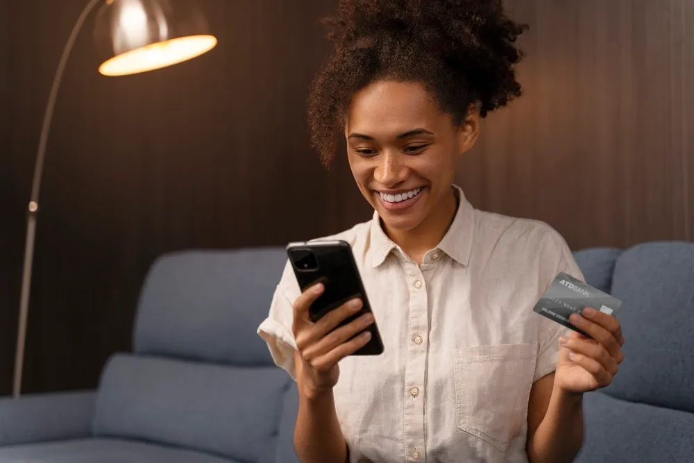 Mulher fazendo pagamento com cartão de crédito em celular