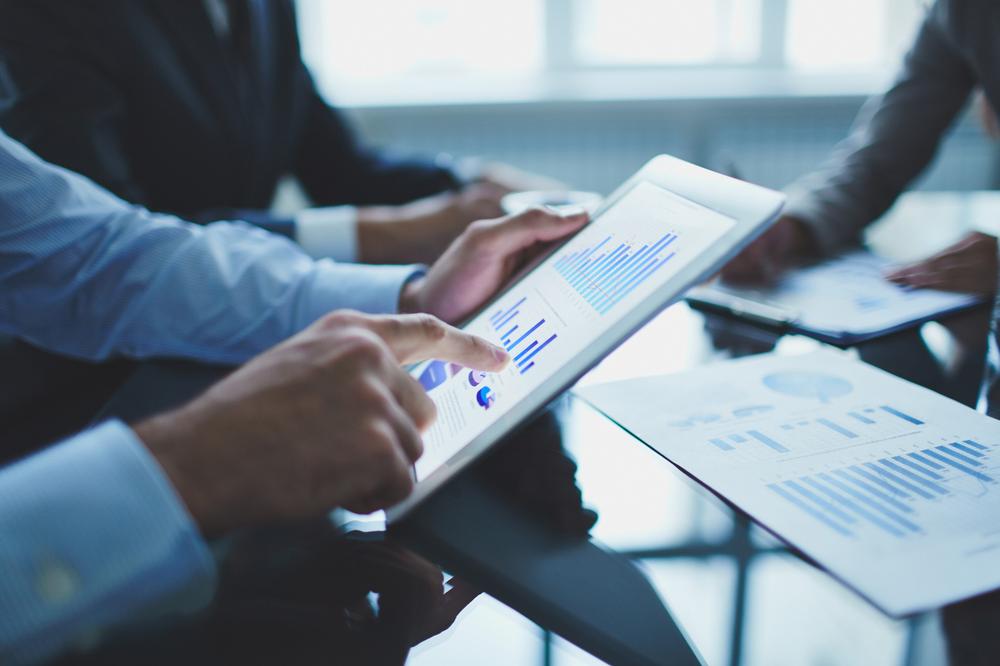 Pessoas consultando CRM em reunião